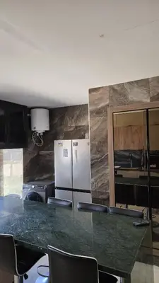a kitchen with a counter with chairs and a refrigerator at Marina casablanca in Casablanca