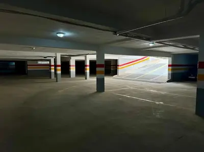 an empty parking garage with columns and colorful walls at Garden Paradise Bouznika Beach Apartment in Bouznika