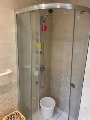 a shower with a glass door in a bathroom at Appart avec Piscine Proche de la Mer in Bouznika