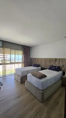 a bedroom with two beds and a large window at Casablanca marina in Casablanca