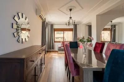 a dining room with a table with chairs and a dining room at Appartement Cosy Proche du Stade in Rabat