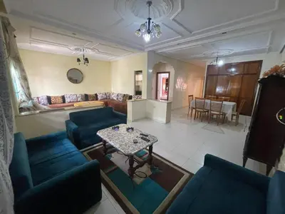 a living room with blue couches and a table at Appt à Harhoura in El Harhoura