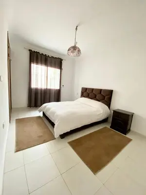 a white bedroom with a large bed and a window at Appt à Harhoura in El Harhoura