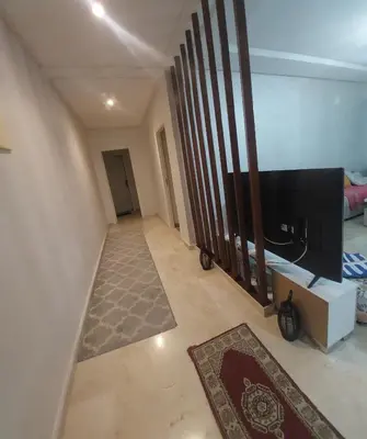 a hallway with a tv and a living room at Goulmim in Mohammedia