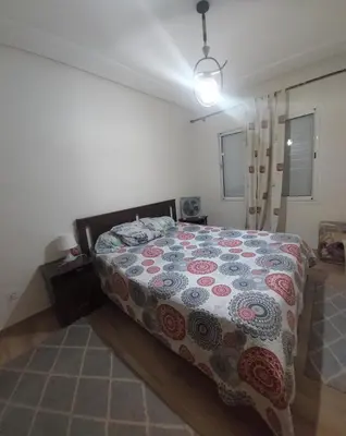 a bedroom with a bed with a quilt on it at Goulmim in Mohammedia