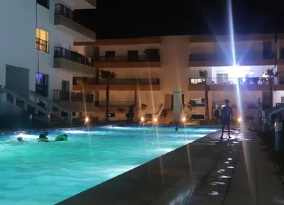 a group of people in a swimming pool at night at Appartement vues piscine in Mansouria