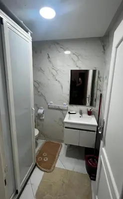 a bathroom with a sink and a shower and a mirror at Appartement vues piscine in Mansouria