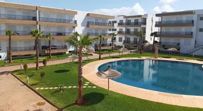 an image of a swimming pool in front of a building at Appartement vues piscine in Mansouria