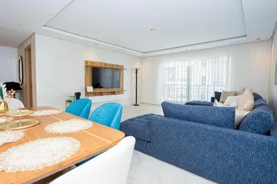 a living room with a blue couch and a table at Appartement géant in Rabat