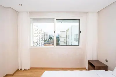 a bedroom with a large window and a bed at Appartement géant in Rabat