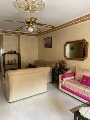 a living room with a couch and a ceiling fan at Appartement Belevédère in Casablanca