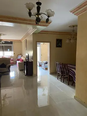 a living room with a ceiling fan and chairs at Appartement Belevédère in Casablanca
