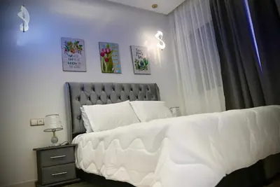 a bedroom with a large bed with white sheets at appartement luxe rabat ville in Rabat