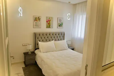 a bedroom with a white bed and a window at appartement luxe rabat ville in Rabat
