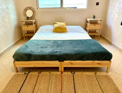 a bedroom with a wooden bed with a green blanket at Perfect for Families & Friends! King & Queen beds in Casablanca