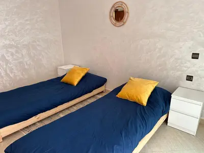 two beds with blue and yellow pillows in a room at Perfect for Families & Friends! King & Queen beds in Casablanca