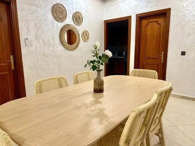 a dining room table with a vase of flowers on it at Perfect for Families & Friends! King & Queen beds in Casablanca