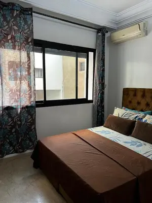a bedroom with a bed and a large window at Studio meublée free in Casablanca