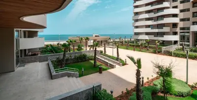 a view of a park with a building and the ocean at Oean view apartment Marina Casablanca in Casablanca