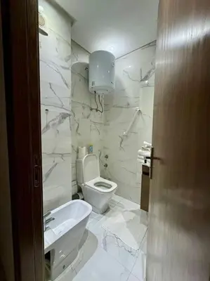 a white bathroom with a toilet and a sink at Stylish 2 bedroom, in the heart of Casablanca in Casablanca