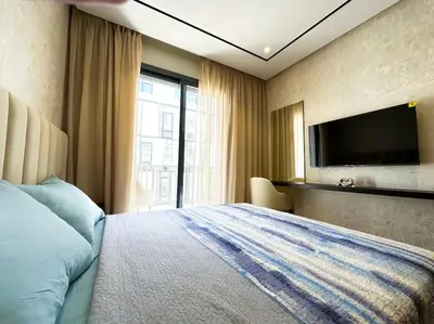 a hotel room with a bed and a flat screen tv at Cozy Studio Calypso 10, CFC à 2min, Parking Dispo in Casablanca