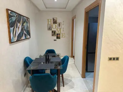 a dining room with a table and blue chairs at appartement Sf in Casablanca