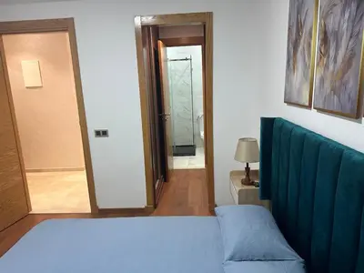 a bedroom with a bed and a door to a hallway at appartement Sf in Casablanca