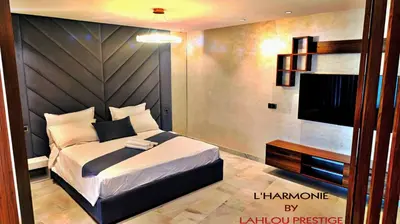 a bedroom with a large bed and a flat screen tv at L'harmonie in Casablanca