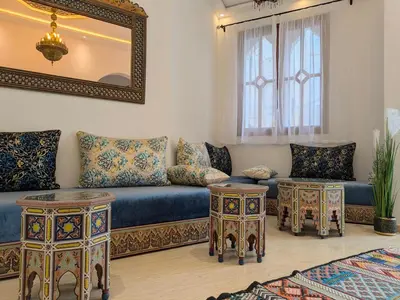 a living room with a couch and two tables at Hôtel Les Remparts in Azemmour
