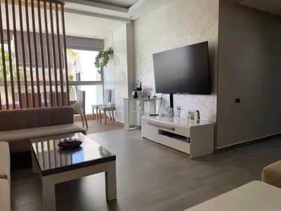 a living room with a couch and a flat screen tv at Rock Island Haut standing in Mohammedia