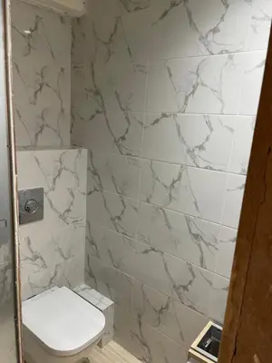 a bathroom with a toilet and a marble wall at Rock Island Haut standing in Mohammedia