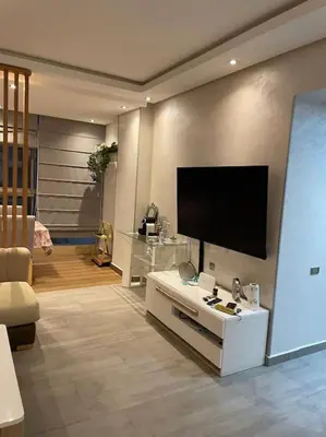 a living room with a flat screen tv on the wall at Rock Island Haut standing in Mohammedia
