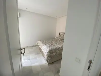 a bedroom with a bed in a white room at Apparemment Meuble a 5 min de l'aéroport casa in Nouaceur