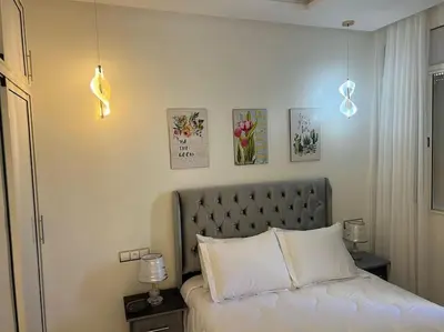 a bedroom with a white bed with a silver headboard at Cozy appartement Rabat in Rabat