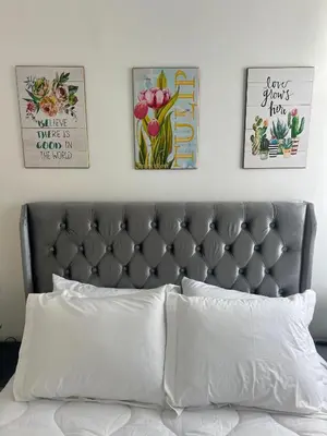 a bedroom with a bed with three pictures on the wall at Cozy appartement Rabat in Rabat