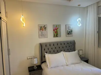 a bedroom with a bed with two lights above it at Cozy appartement Rabat in Rabat