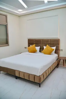 a bedroom with a large bed with yellow pillows at Les portes de Temara in Temara