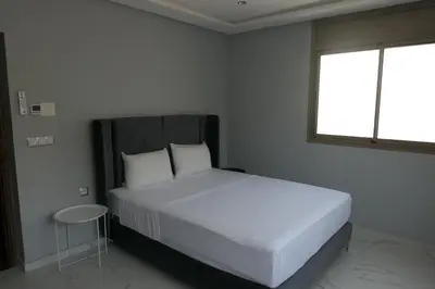 a bedroom with a white bed with a window at Les portes de Temara in Temara