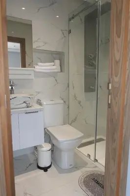 a bathroom with a toilet and a glass shower at Les portes de Temara in Temara