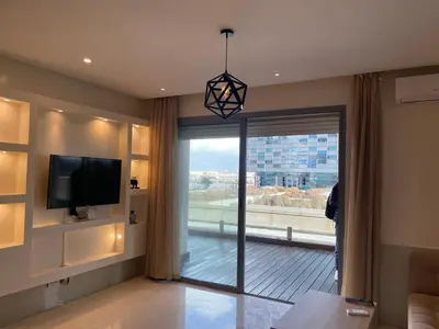 a living room with a tv and a large window at Charming Seaview Apartment 4 in Casablanca