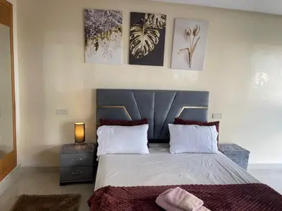 a bedroom with a large bed with a blue headboard at Charming Seaview Apartment 4 in Casablanca
