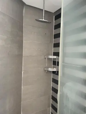 a bathroom with a walkin shower with black and white tiles at Charming Seaview Apartment 4 in Casablanca