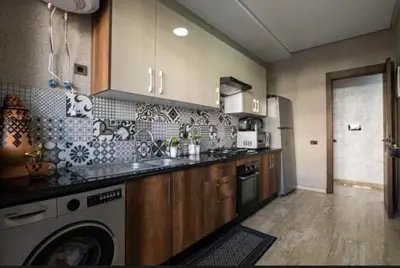 a kitchen with a sink and a dishwasher at Les crêtes dar bouazza in Casablanca