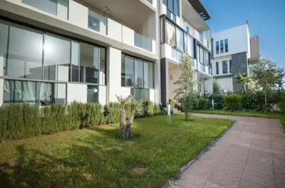 a large apartment building with a garden in front of it at Les crêtes dar bouazza in Casablanca
