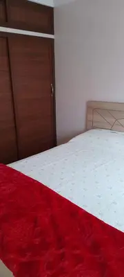 a bedroom with a bed with a red blanket on it at Appartement à Bernoussi Casablanca in Casablanca