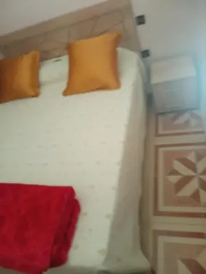 a white bed with two pillows on top of it at Appartement à Bernoussi Casablanca in Casablanca