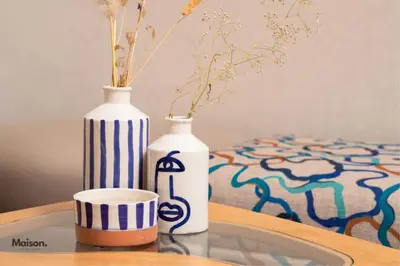 two vases are sitting on a table with a cup at Luxury Suite Mannesmann - Seaview in Mohammedia