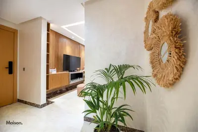 a living room with a potted plant and a television at Luxury Suite Mannesmann - Seaview in Mohammedia