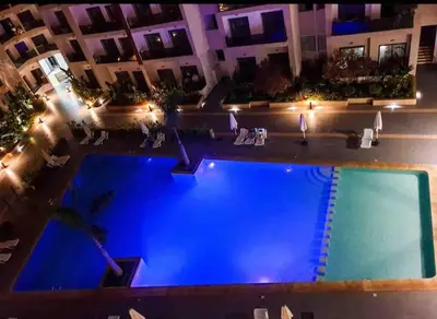 an overhead view of a swimming pool at night at Luxury Suite Mannesmann - Seaview in Mohammedia