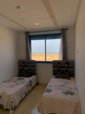 a bedroom with two beds and a window at Résidence Perla Andalusia Vue Sur Mer in Mansouria